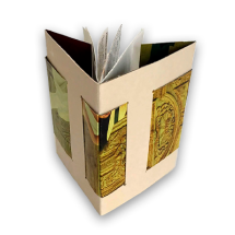 Imagem de uma peça artística em formato de livro ou livreto tridimensional, com estrutura em papel dobrado formando ângulos retos. As faces externas apresentam colagens com detalhes ornamentais, parecendo recortes de revista. O interior contém páginas parcialmente abertas, sugerindo conteúdo textual ou visual. A obra combina elementos visuais e táteis com referências históricas.