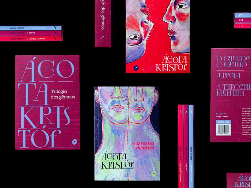 Imagem com fundo preto exibe diversas capas e lombadas da trilogia "O Grande Caderno", "A Prova" e "A Terceira Mentira", da escritora Ágota Kristóf. As capas, com design gráfico marcante e tons vibrantes de vermelho, rosa, azul e roxo, mostram rostos e figuras duplicadas, remetendo à temática dos gêmeos presente na obra. O nome da autora aparece em destaque, com tipografia moderna e artística.