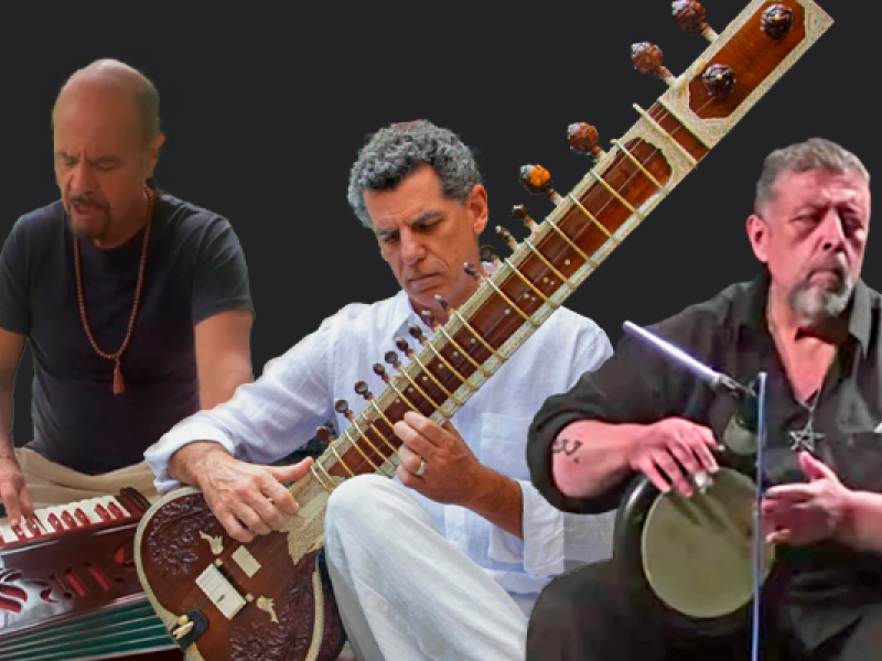 Integrantes do Trio Shiva Gita (Índia) em montagem promocional. Ao centro, um músico toca uma sitar, instrumento tradicional indiano de cordas. À esquerda, outro integrante toca um harmonium, teclado de fole utilizado na música clássica e devocional da Índia. À direita, um percussionista executa um tambor de mão. Os três aparecem sobre fundo escuro, destacando os instrumentos e a diversidade sonora do grupo.